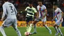 Penyerang Manchester City Riyad Mahrez (kedua kiri) memainkan bola melewati pemain Barcelona Sergio Busquets dan Jordi Alba pada sebuah laga amal di Stadion Camp Nou, Kamis (25/8/2022) dini hari WIB. Laga Barcelona vs Man City berjalan ketat, skor akhir sama kuat 3-3. (AP Photo/Joan Monfort)