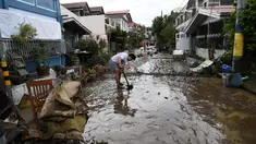 Seorang warga menyekop lumpur dari jalananan setelah banjir akibat Topan Goni di Kota Batangas, selatan Manila, Filipina, Senin (2/11/2020). Badan Bencana Negara mencatat sedikitnya 16 orang tewas akibat topan terkuat di dunia tahun ini, yang menghantam Filipina pada hari Minggu. (TED ALJIBE / AFP)