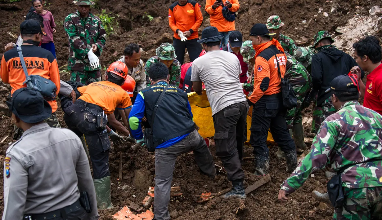 Tim SAR mengevakuasi jasad seorang wanita dari reruntuhan material longsor di Kabupaten Ponorogo, Jawa Timur, Minggu (2/4). Bencana tanah longsor yang terjadi Sabtu kemarin menimbun puluhan rumah, sedangkan 28 warga dinyatakan hilang. (JUNI KRISWANTO/AFP)