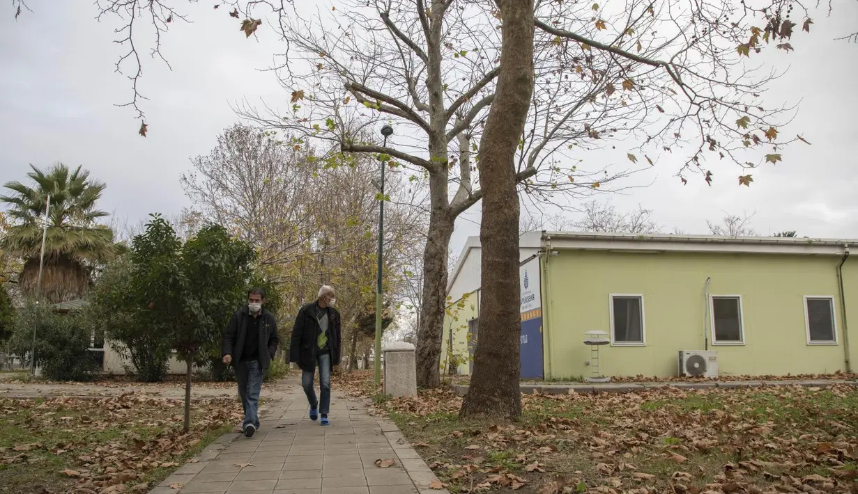 Dua orang tunawisma berjalan di sebuah pusat akomodasi di Istanbul, Turki, pada 21 Desember 2020. Sejauh ini, 350 lebih tunawisma telah ditampung di pusat akomodasi yang sebelumnya diperuntukkan bagi penyandang disabilitas dan keluarga mereka. (Xinhua/Osman Orsal)