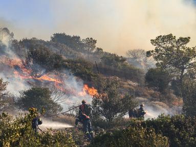 Petugas pemadam kebakaran berupaya memadamkan kebakaran hutan yang terjadi di Ierapetra, pulau Kreta, Yunani selatan, pada Kamis 3 Juli 2025. (Costas Metaxakis/AFP)