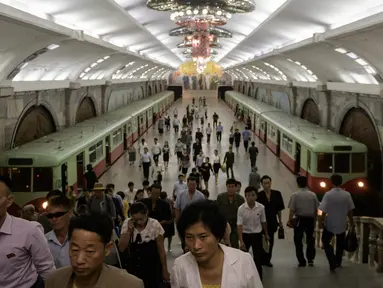 Para komuter berjalan melalui stasiun kereta bawah tanah atau metro Pyongyang di Korea Utara, 6 September 2018. Kereta bawah tanah Pyongyang Membentang sepanjang 22,5 km dengan 17 stasiun pemberhentian. (AFP / Ed JONES)