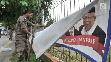 Petugas Satpol PP mencopot spanduk APK di sepanjang Jalan Yos Sudarso, Jakarta Utara, Rabu (13/3). Bawaslu menginstruksikan Pemkot se-DKI Jakarta untuk menertibkan APK yang dipasang di sembarang tempat dan fasilitas umum. (merdeka.com/Iqbal S. Nugroho)