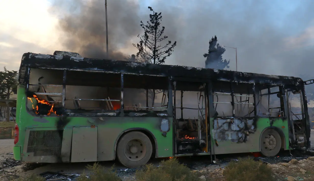 Bangkai bus yang diserang dan dibakar oleh kelompok pemberontak saat dalam perjalanan ke al-Foua dan Kefraya di dekat Idlib, Suriah, Minggu (18/12). Bus itu sedianya untuk mengevakuasi warga yang sakit dan terluka di Aleppo timur. (REUTERS/Ammar Abdullah)