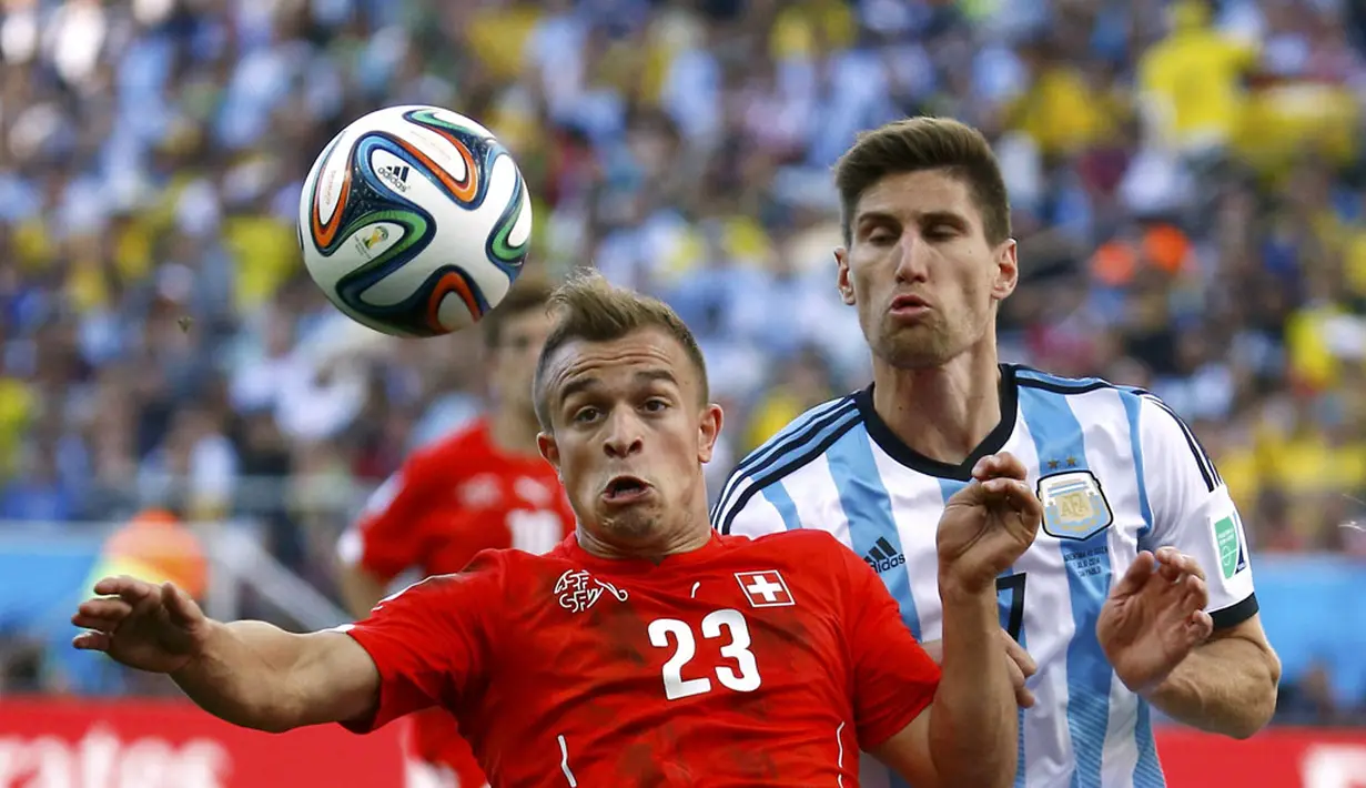 Pemain tengah Timnas Swiss, Xherdan Shaqiri (kiri), berebut penguasaan bola dengan Federico Fernandez (Argentina) di laga 16 besar Piala Dunia 2014 di Stadion Corinthians, Sao Paulo, (1/7/2014). (REUTERS/Kai Pfaffenbach)