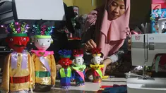 Perajin menyelesaikan pembuatan miniatur ondel-ondel di rumah produksi Kramat Jati, Jakarta, Senin (23/6/2019). Miniatur ondel-ondel yang terbuat dari limbah botol plastik itu dibuat sesuai dengan pesanan. (merdeka.com/Arie Basuki)