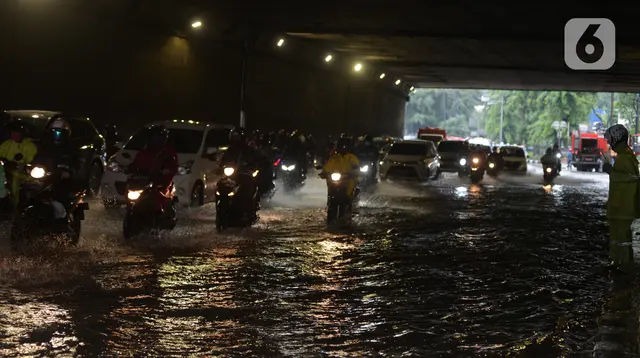 Pengendara sepeda motor menerjang banjir nan merendam terowongan di Cawang, Jakarta, Jumat (19/2/2021). Hujan nan turun sejak semalam membikin sejumlah jalanan di Ibu Kota tergenang banjir dengan ketinggian sekitar 30-50 cm. (merdeka.com/Imam Buhori)