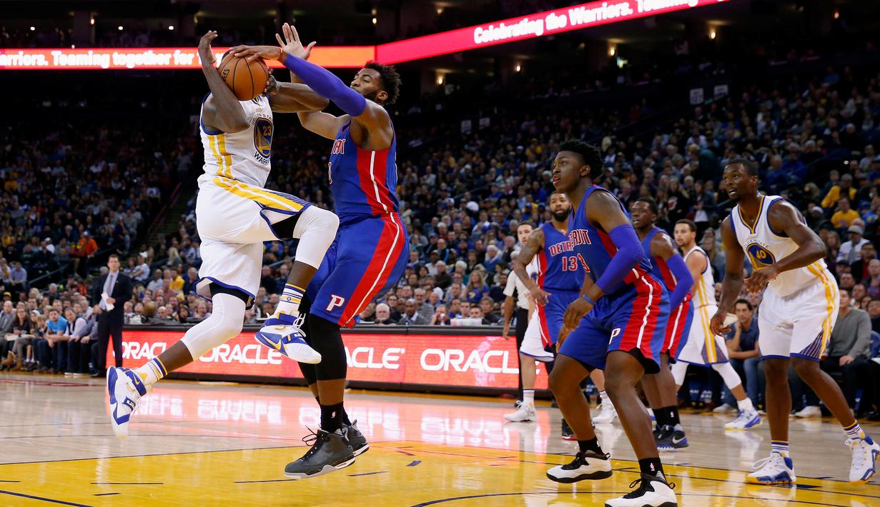 Pebasket Golden State Warriors Draymond Green kehilangan kontrol bola saat dibayangi pebasket Detroit Pistons Andre Drummond di ORACLE Arena, California, Senin (9/11/2015). Warriors menang 109-95. (Getty Images/AFP/Ezra Shaw)