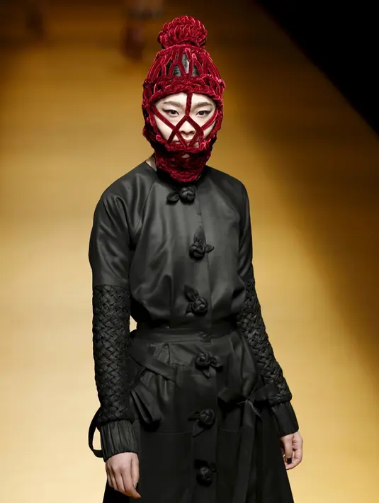 Seorang model mengenakan busana dari desainer asal Vietnam, Nguyen Cong Tri dalam koleksi Musim Autumn / Winter 2016 di Tokyo Fashion Week, Jepang , 15 Maret 2016. Uniknya dalam peragaan busana ini menggunakan topeng. (REUTERS / Issei Kato)