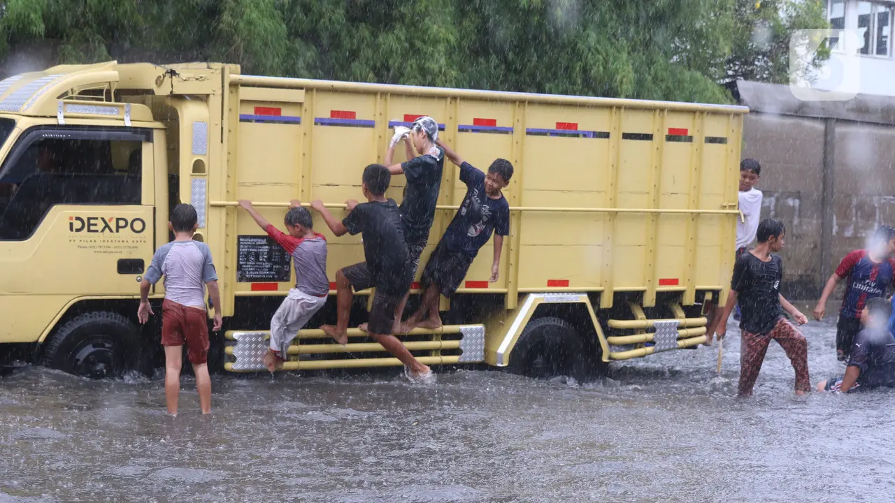 Meski Berbahaya, Banjir Jadi Lahan Favorit Anak-Anak Bermain Air
