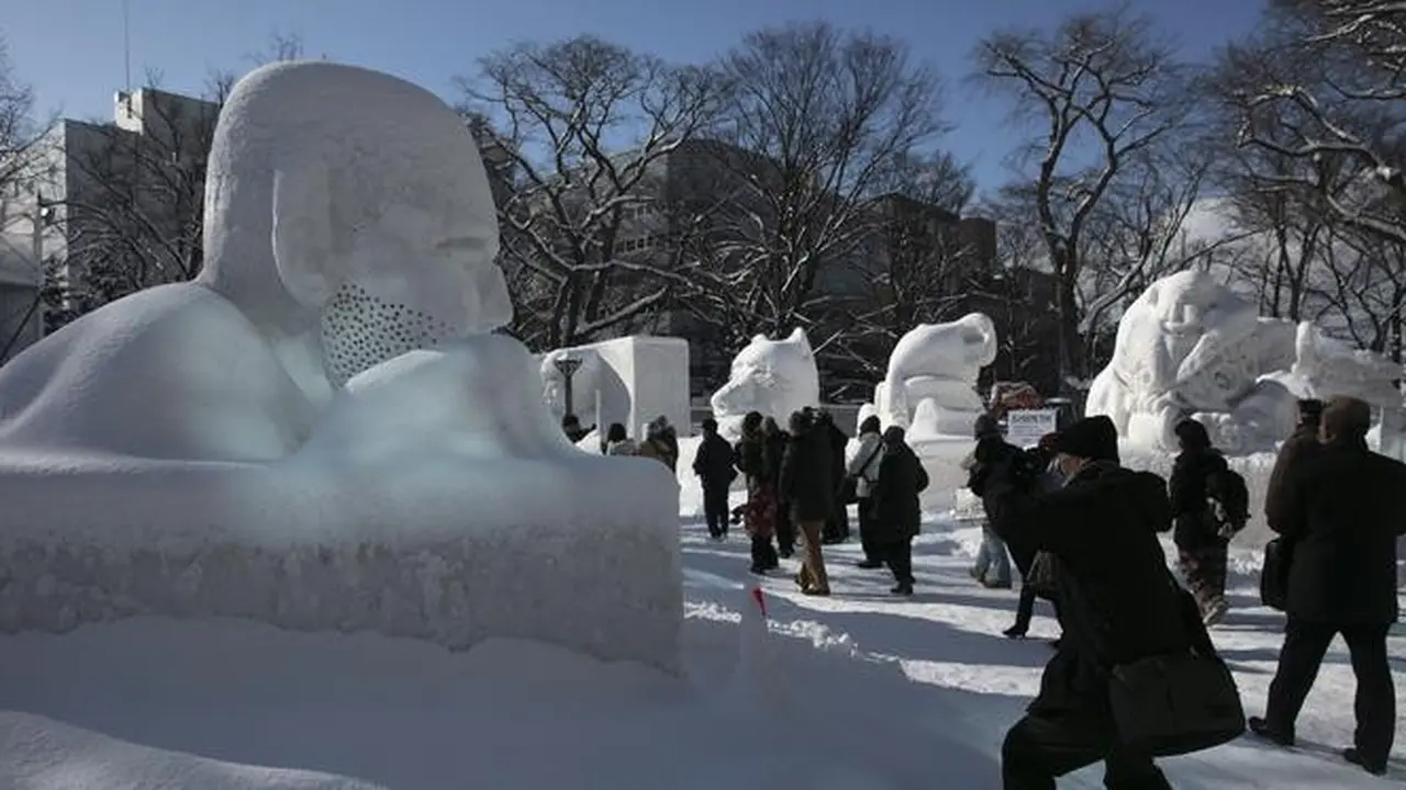 Pengunjung melihat patung-patung salju selama Festival Salju Sapporo ke-71 di Taman Odori di Sapporo, Jepang, Selasa, (4/2/2020).