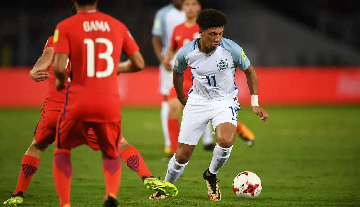 Pemain Timnas Inggris U-17, Jadon Sancho (kanan) menggiring bola melewati adangan pemain Chile saat laga Grup F Piala Dunia U-17 2017 di Salt Lake Stadium, Kolkata, India, 8 Oktober 2017. Sementara itu, Inggris tergabung dalam Grup F bersama Iraq, Meksiko, dan Chile. (AFP/Dibyangshu Sarkar)