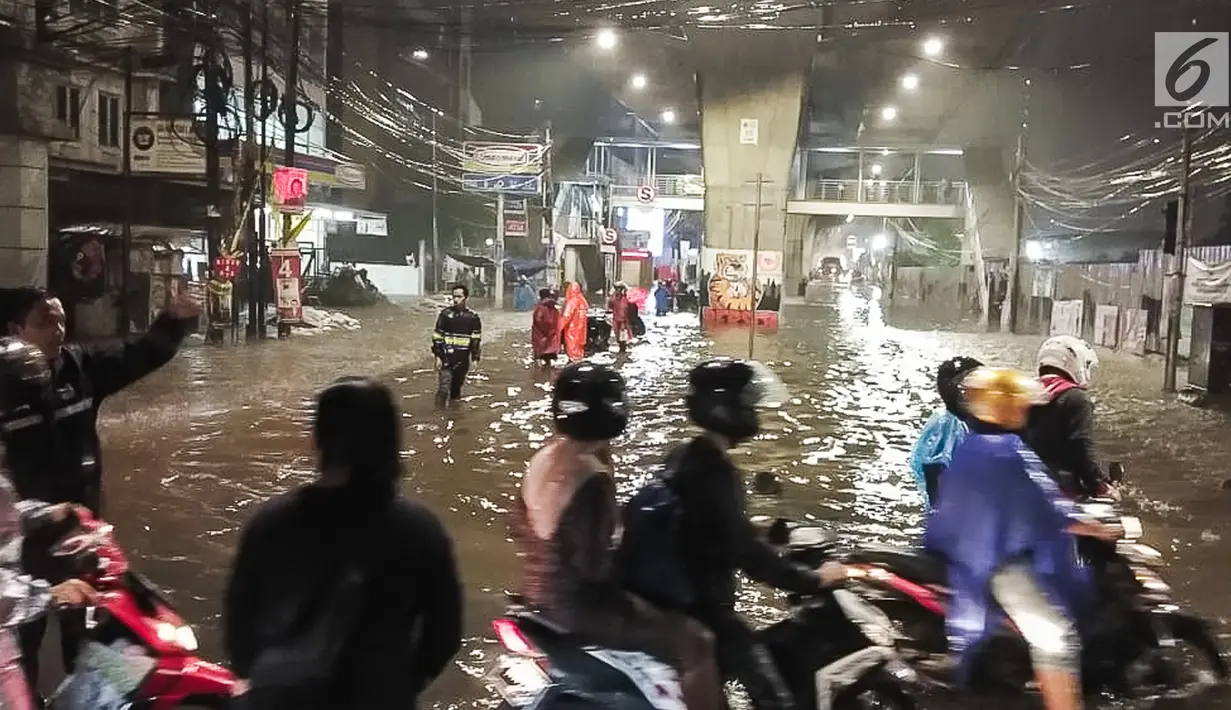 Banjir menggenangi kawasan Simpang Seskoal, Kebayoran Lama, Jakarta, Sabtu malam (16/2). Hujan deras sejak pukul 22.00 WIB mengakibatkan saluran pembuangan berukuran kecil tersumbat. (Liputan6.com/Septian)