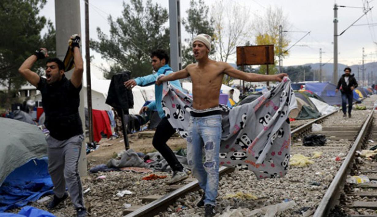 Imigran memberikan perlawanan saat Polisi Makedonia melarang para imigran mendirikan tenda di sekitar rel kereta api di Desa Idomeni, Yunani (28/11/2015). (REUTERS/Yannis Behrakis)