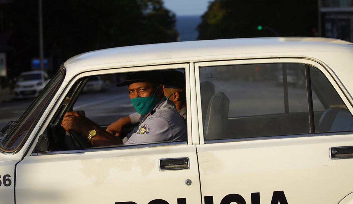 Polisi yang mengenakan masker berpatroli di jalanan kosong saat penerapan jam malam di Havana, Kuba, Selasa (1/9/2020). Otoritas Kuba menerapkan lockdown selama 15 hari di Havana untuk keluar dari penularan COVID-19 tingkat rendah tetapi terus-menerus. (AP Photo/Ramon Espinosa)