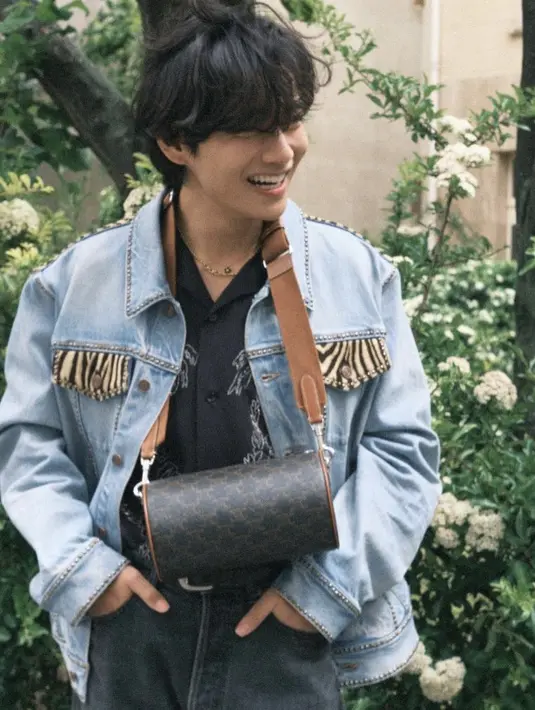 Penampilannya pun dilengkapi dengan sabuk kecil hitam crocodile embossed calfskin. Dan membawa cylinder bag in triomphe canvas tan seharga Rp25 jutaan.  Credit: Celine
