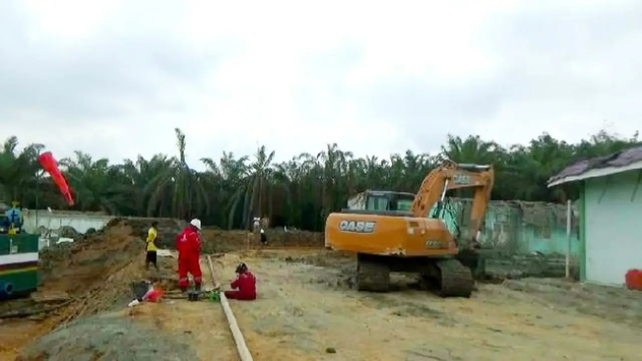 Petugas membersihkan lumpur hasil semburan gas di Pesantren Al Ihsan Pekanbaru.
