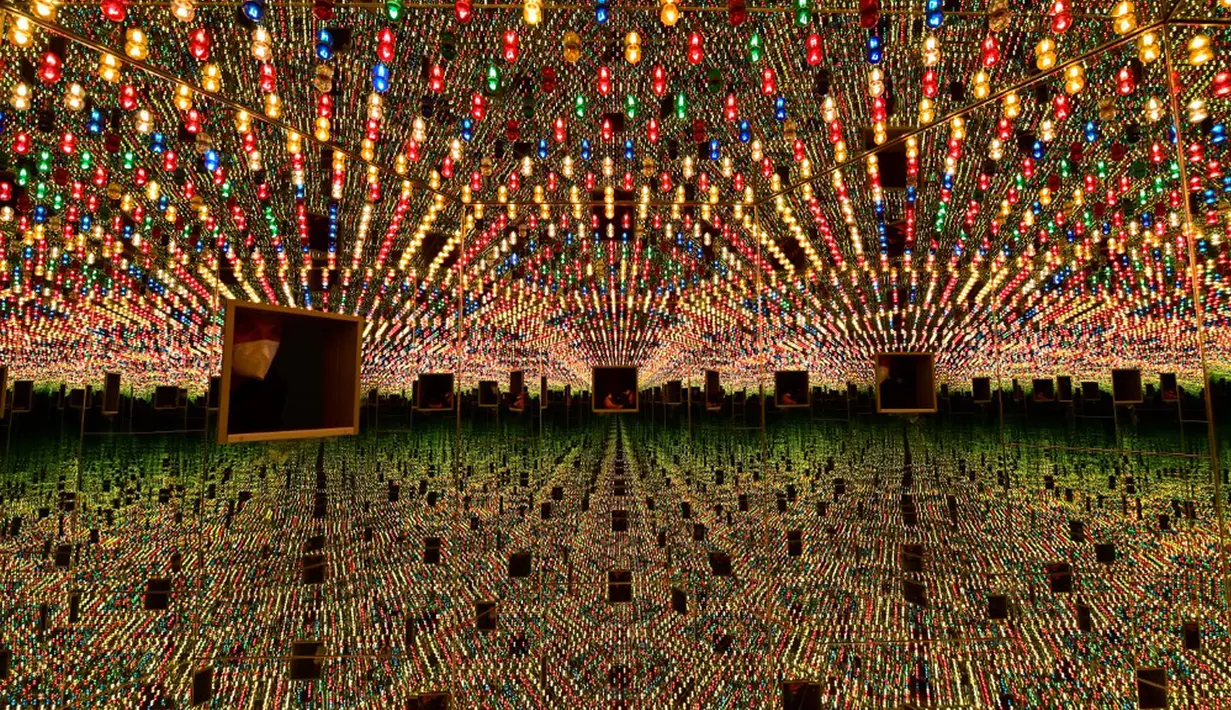 Seorang pengunjung difoto saat melihat ke dalam ruang cermin heksagonal berjudul 'Kusama's Peep Show or Endless Love Show' (1966) karya seniman Jepang Yayoi Kusama dalam pameran Yayoi Kusama: A Retrospective di Atrium Martin Gropius Bau, Berlin, Jerman, Selasa (19/5/2021). (John MACDOUGALL/AFP)