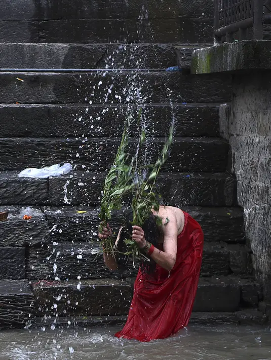 Seorang wanita Hindu Nepal mandi suci di sungai Bagmati selama festival Rishi Panchami di Kathmandu (3/9/2019). Rishi Panchami menandai berakhirnya Festival Teej selama tiga hari, dirayakan di Nepal dan beberapa bagian India oleh wanita Hindu yang sudah menikah. (AFP Photo/Prakash Mathema)