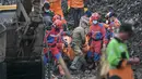 Hingga Senin 9 Maret 2026, total lima korban telah dievakuasi dalam keadaan meninggal dunia. Tampak dalam foto, tim penyelamat mengevakuasi korban longsor di Tempat Pembuangan Sampah Terpadu (TPST) Bantargebang, Bekasi, Jawa Barat, pada 9 Maret 2026. (BAY ISMOYO/AFP)