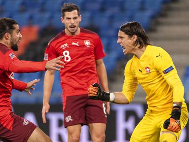 Kiper Swiss, Yann Sommer, melakukan selebrasi usai berhasil menggagalkan tendangan penalti Sergio Ramos pada laga UEFA Nations League di Stadion St. Jakob-Park, Minggu (15/11/2020). Kedua tim bermain imbang 1-1. (Alessandro della Valle/Keystone via AP)