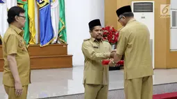 Pelaksana Tugas Gubernur Aceh, Nova Iriansyah menyerahkan surat penugasan Pelaksana Tugas (Plt) Bupati kepada Wakil Bupati Bener Meriah Tgk. H. Sarkawi di Kemendagri Jakarta, Senin (9/7). (Liputan6.com/Herman Zakharia)