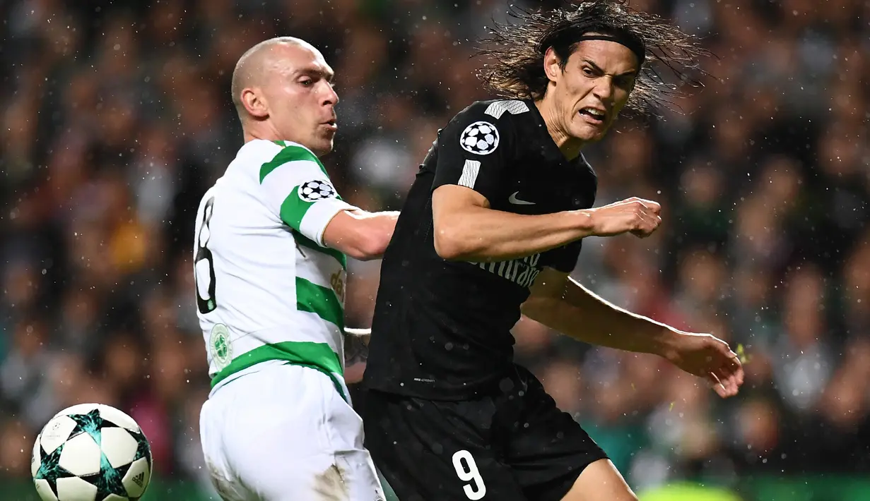 Pemain PSG, Edinson Cavani berebut bola dengan gelandang Celtic, Scott Brown pada pertandingan perdana fase grup Liga Champions di Stadion Celtic Park, Selasa (12/9). Paris Saint-Germain pesta lima gol ke gawang Celtic. (FRANCK FIFE / AFP)