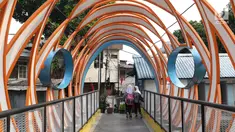 Dua pelajar melintasi Jembatan Ketupat di Jalan Gajah Mada, Petojo, Jakarta, Kamis (8/8/2019). Jembatan Ketupat memiliki bentang 12,5 meter dan lebar 2,5 meter dengan waktu pengerjaan selama 45 hari. (Liputan6.com/Helmi Fithriansyah)