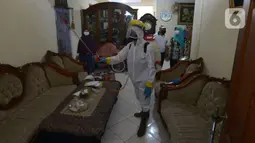 Petugas PMI menyemprotkan cairan disinfektan di salah satu rumah di Perumahan Ori Pondok Bambu, Jakarta, Kamis (10/2/2022). Penyemprotan ini dilakukan pada lingkungan perumahan sebagai upaya untuk menekan angka penyebaran Virus Covid-19 varian Omicron yang terus meningkat. (merdeka.com/Imam Buhori)