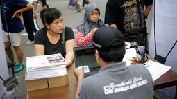 Warga mendaftarkan namanya di posko KPUD DKI di kawasan Bundaran HI, Jakarta, Minggu (26/3). KPUD Jakarta membuka posko pemeriksaan data pemilih terdaftar untuk Pilkada DKI 2017 putaran kedua. (Liputan6.com/Faizal Fanani)