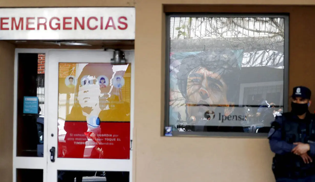 Petugas Kepolisian berjaga di depan Rumah Sakit di La Plata, Argentina, Selasa (3/11/2020). Sejumlah fans Argentina berkumpul di depan rumah sakit untuk memberi dukungan kepada sang legenda. (AP/Natacha Pisarenko)