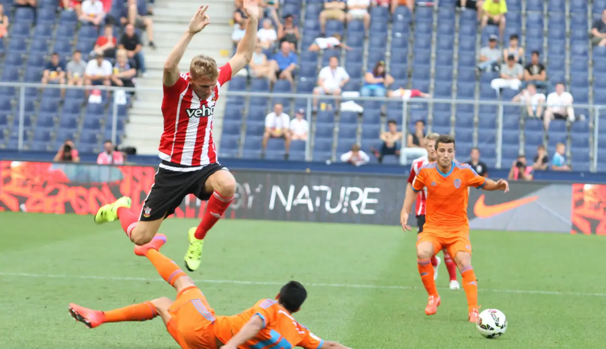 Bek Southampton, Jason McCarthy lompat menghindari tekel keras dari bek Valencia, Enzo Perez. (Bola.com/Reza Khomaini)