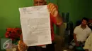 Warga menunjukkan surat pemberitahuan dari Kecamatan Penjaringan di Kampung Aquarium, Jakarta Utara, Senin (28/3). Surat pemberitahuan berisi penertiban hunian yang menempati Kawasan Pasar Ikan dan Luar Batang. (Liputan6.com/Gempur M Surya)