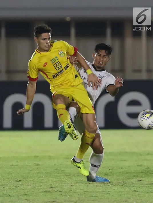 Pemain depan Bhayangkara FC, Ramiro Ezequiel Fergonzi (depan) berebut bola dengan bek Madura United, Guntur Ariyadi pada lanjutan Shopee Liga 1 Indonesia 2019 di Stadion Madya Gelora Bung Karno, Jakarta, Senin (5/8/2019). Laga kedua tim berakhir imbang 1-1. (Liputan6.com/Helmi Fithriansyah)