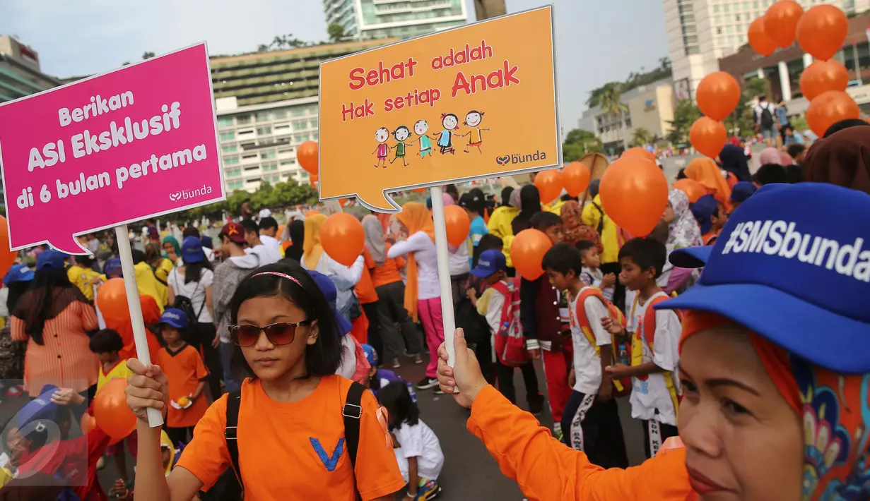 Peserta aksi membawa poster dalam aksi peringati Hari Gizi Nasional di kawasan Bunderan HI, Jakarta, Minggu (31/2/2015). Dalam aksinya memberikan memberitahukan pentingnya sayur mayur diberikan untuk anak. (Liputa6.com/Faizal Fanani)