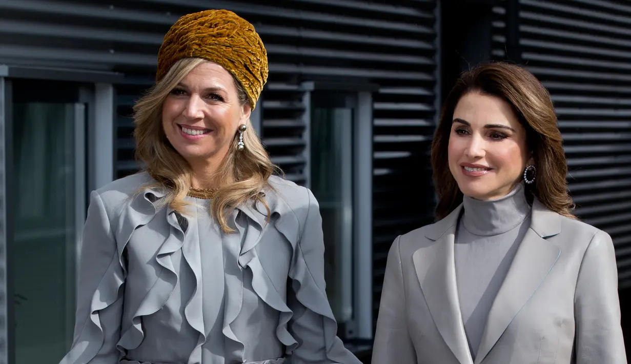 Ratu Belanda Maxima (kiri) berpose untuk foto bersama Ratu Yordania Rania saat berkunjung ke sekolah Mondriaan ROC di Den Haag, Belanda (21/3). Kedua ratu itu tampil senada menggunakan busana berwarna abu-abu. (AP Photo / Peter Dejong)