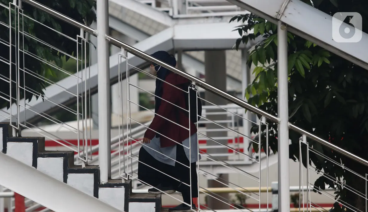 Warga menaikii tangga JPO di Jalan HR Rasuna Said, Jakarta, Kamis (7/1/2021). Untuk menyeragamkan kebijakan pengendalian COVID-19, Gubernur DKI Jakarta akan segera menerbitkan Pergub untuk Pemberlakuan Pembatasan Kegiatan Masyarakat (PPKM) pada 11-25 Januari 2021. (Liputan6.com/Helmi Fithriansyah)