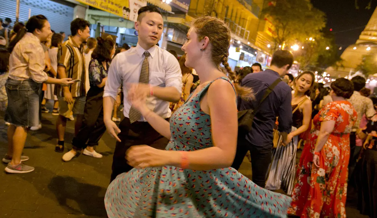 Warga asing menari di depan kuil Phra Pathom Chedi di provinsi Nakhon Pathom, Thailand (25/2). Lebih dari 300 peserta termasuk penari asing bernari menghebohkan sebuah jalan sekitar satu jam. (AFP Photo/Thai News Pix/Krit Promsakla Na Sakolnakorn)