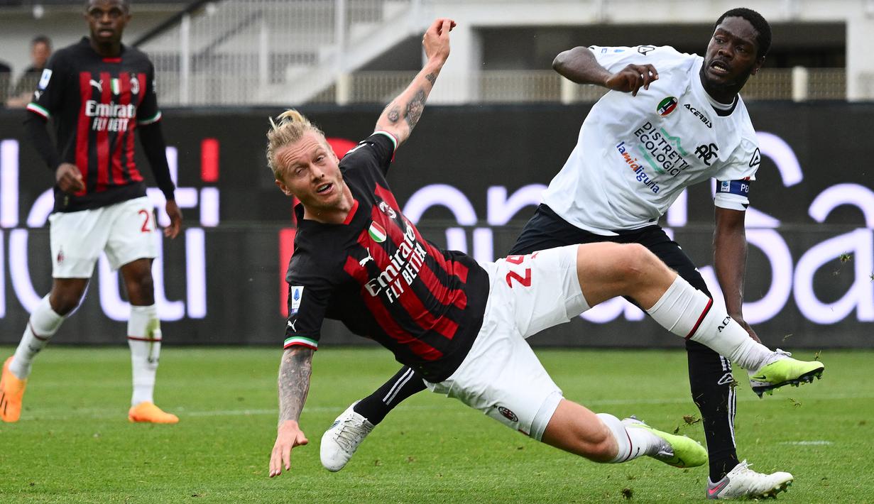 Pemain AC Milan, Simon Kjaer, terjatuh saat berebut bola dengan pemain Spezia, Emmanuel Gyasi, pada laga Liga Italia di Stadion Alberto-Picco, Minggu (14/5/2024). AC Milan takluk dengan skor 0-2 dari Spezia. (AFP/Vincenzo Pinto)