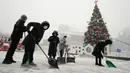 Pekerja membersihkan salju dari trotoar di sepanjang City Hall Plaza, Seoul, Korea Selatan, 15 Desember 2022. (AP Photo/Ahn Young-joon)