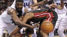 Pemain Miami Heat, Justise Winslow (tengah)  berebut bola dengan pemain Charlotte Hornets, Roy Hibbert (kiri) pada laga NBA di Spectrum Center, (29/12/2016). Hornets menang 91-82. (Reuters/Sam Sharpe-USA TODAY Sports)