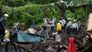 Pasukan Tanggap Bencana Nasional dan tim penyelamat lainnya memeriksa lokasi tanah longsor di daerah kumuh di Mumbai, India, Minggu (18/7/2021). Sebanyak 18 orang tewas setelah beberapa rumah hancur oleh dinding yang runtuh dan akibat tanah longsor yang dipicu oleh hujan lebat. (Sujit Jaiswal/AFP)