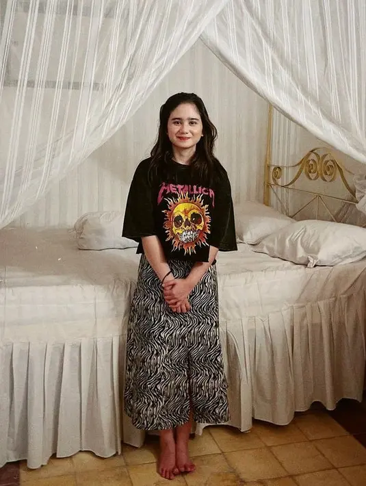 Tissa Biani memadukan midi skirt hitam bercorak, cukup dengan t shirt bandnya. [@tissabiani]