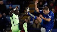 Bek Manchester City, Bacary Sagna (kiri), berebut bola dengan gelandang Leicester City, Marc Albrighton (kanan), pada laga di King Power Stadium, Rabu (30/12/2015) dini hari WIB. (AFP/Adrian Dennis)
