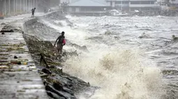 Warga mencari mencari botol-botol plastik untuk didaur ulang ditengah deburan gelombang akibat Topan Koppu di Teluk Manila, Minggu (18/10). Topan kuat itu membuat 10.000 orang terpaksa mengungsi, kata tim SAR setempat. (REUTERS/Romeo Ranoco)
