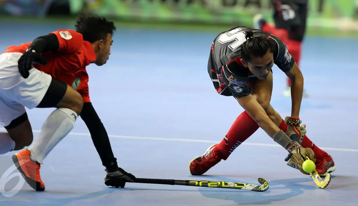 Kapten tim hoki putra DKI Jakarta, Daarul Quthni (kanan) berebut bola dengan pemain Jawa Barat saat laga final hoki PON XIX Jabar di Gymnasium UPI, Bandung, Senin (19/9). Jawa Barat menundukan DKI Jakarta dengan skor 3-1. (Liputan6.com/Helmi Fithriansyah)