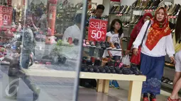 Pengunjung usai mengunjungi salah satu toko sepatu yang memberikan diskon di Pusat Perbelanjaan Pasar Baru, Jakarta, Selasa (21/6). Menjelang Lebaran, Pasar Baru menawarkan berbagai promo dengan diskon yang bervariasi. (Liputan6.com/Immanuel Antonius)