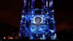 Pemandangan saat Gereja Katedral Notre-Dame de Paris dihiasi cahaya, Prancis (11/11). Pertunjukan cahaya ini dalam rangka peringatan Hari Gencatan Senjata yang menandai berakhirnya Perang Dunia I. (AFP Photo/Francois Guillot)
