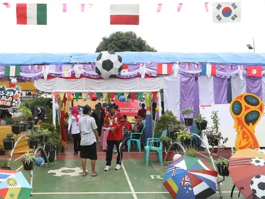 Aktivitas di TPS 29 Gandasari yang bertema Piala Dunia pada Pilkada Serentak 2018 di Kota Tangerang, Rabu (27/6). TPS ini membuat warga yang menggunakan hak pilih untuk Pilkada Kota Tangerang merasakan sensasi Piala Dunia 2018. (Liputan6.com/Angga Yuniar)