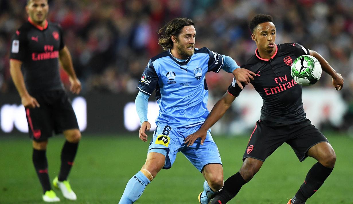 Gelandang Arsenal, Cohen Bramall, berusaha melewati gelandang Sydney FC, Joshua Brillante, pada laga persahabatan di Stadion ANZ, Sydney, Kamis (13/7/2017). Arsenal menang 2-0 atas Sydney FC. (EPA/David Moir)